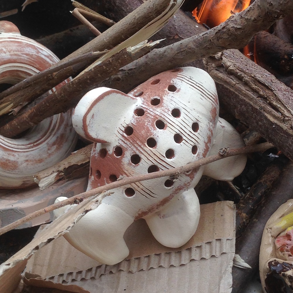 pottery fish and pottery experiments being smoke fired on a bbq