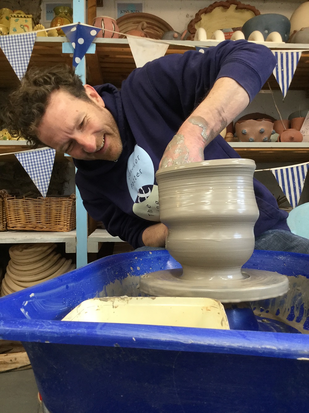 artist jon williams making a pot on the potter's wheel at eastnor pottery