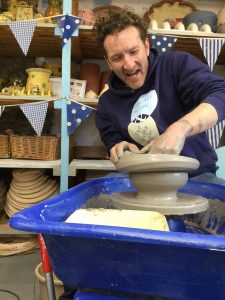 jon the potter making a very wobbly pot on the potter's wheel