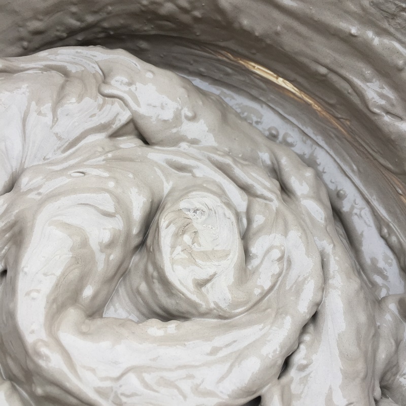 swirl pattern in a bucket of thick pottery slip